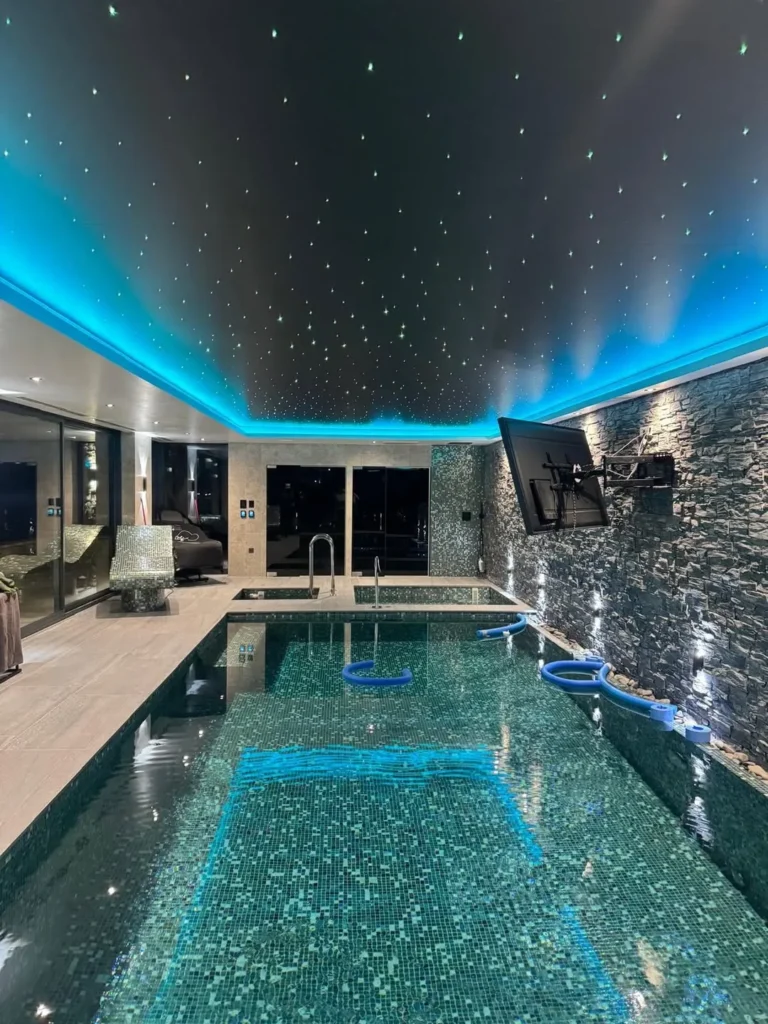 Indoor Pool With Starry Ceiling and Dark Stone Walls
