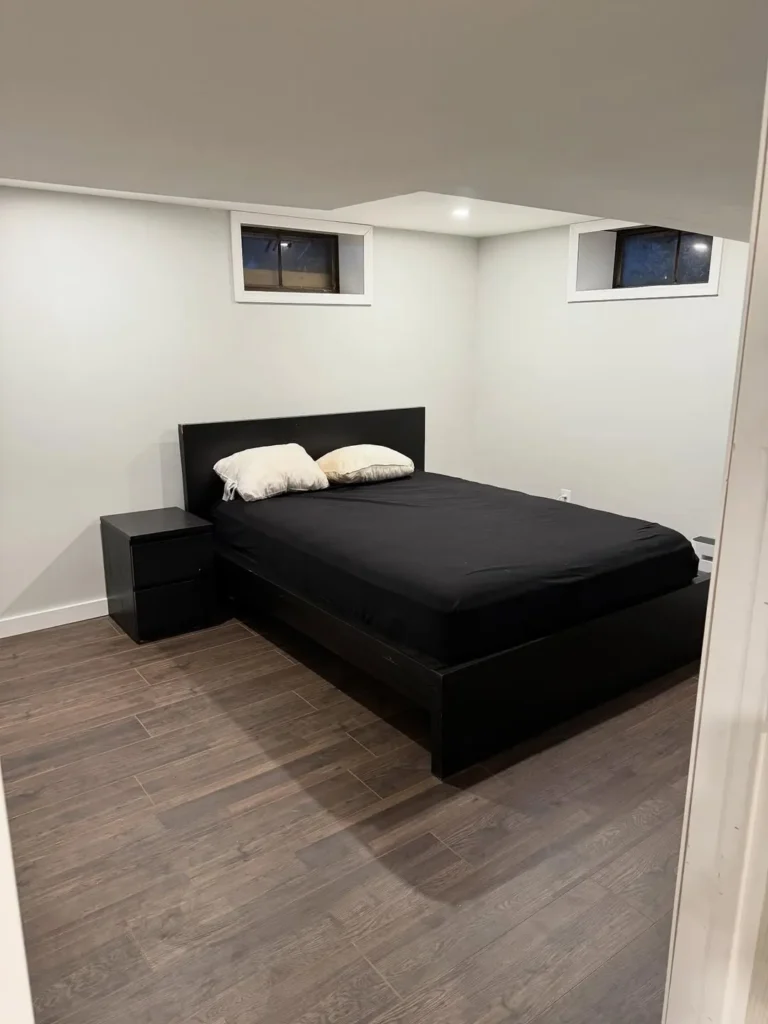Simple Basement Bedroom With Dark Wood Flooring